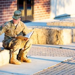 Soldier sitting outside with a laptop