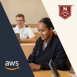 Image showing two individuals in a classroom setting, focusing on one person in a dark navy outfit who seems engaged in their work, with another person in a light-colored military uniform blurred in the background. The logos of Norwich University and Amazon Web Services (AWS) are displayed in the upper right and lower left corners respectively.