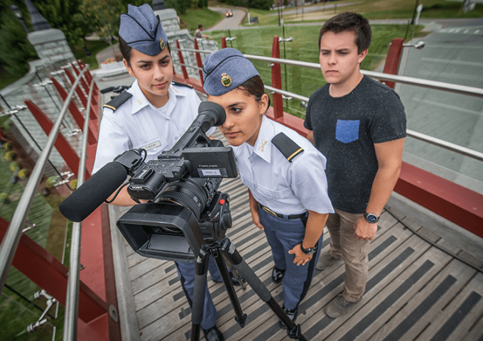 Corps and civilian students working with large camera equipment on the bridge.