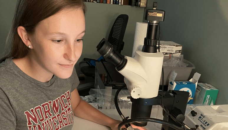 Student doing research surrounded by equipment.