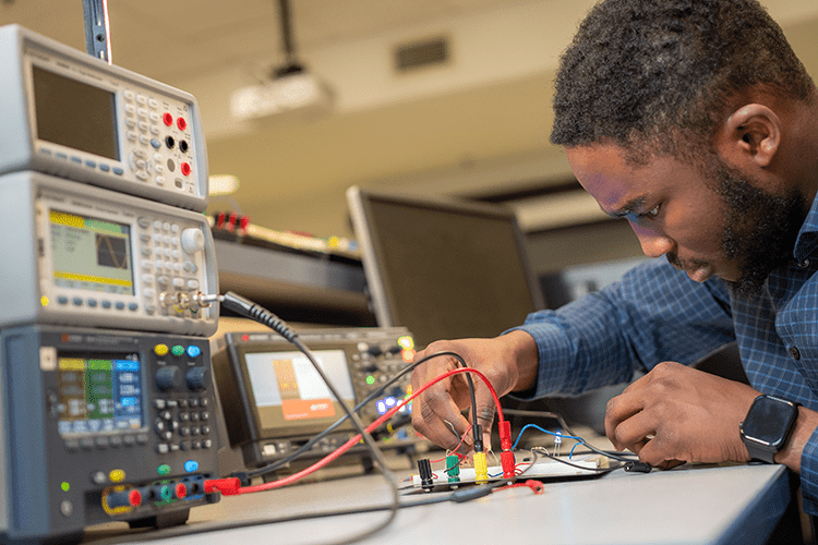 Student works on electrical engineering project.