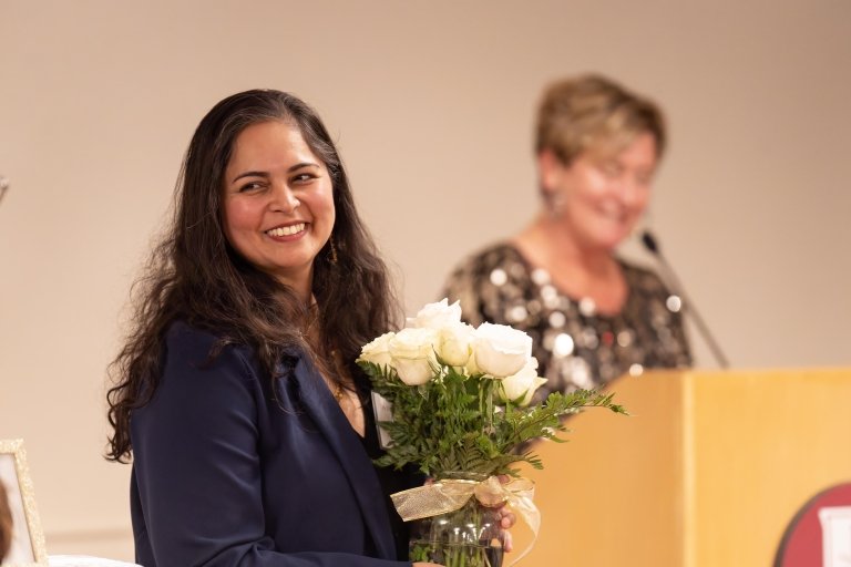 Dr. Tara Kulkarni, finalist for The ATHENA Leadership Award®, holding flowers