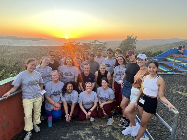 Norwich University School of Nursing students and professors posing for a group photo overlooking a scenic outlook on their Costa Rica